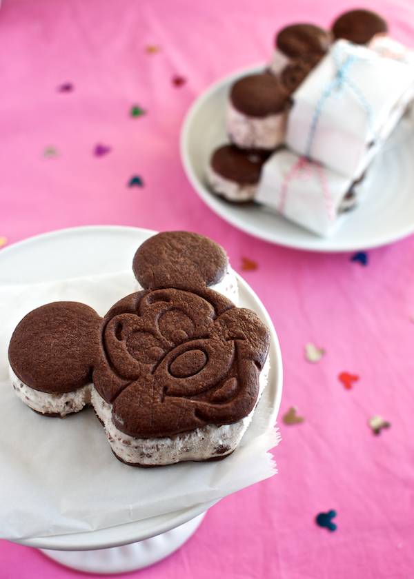 Mickey shaped ice cream sandwiches on a stand. 