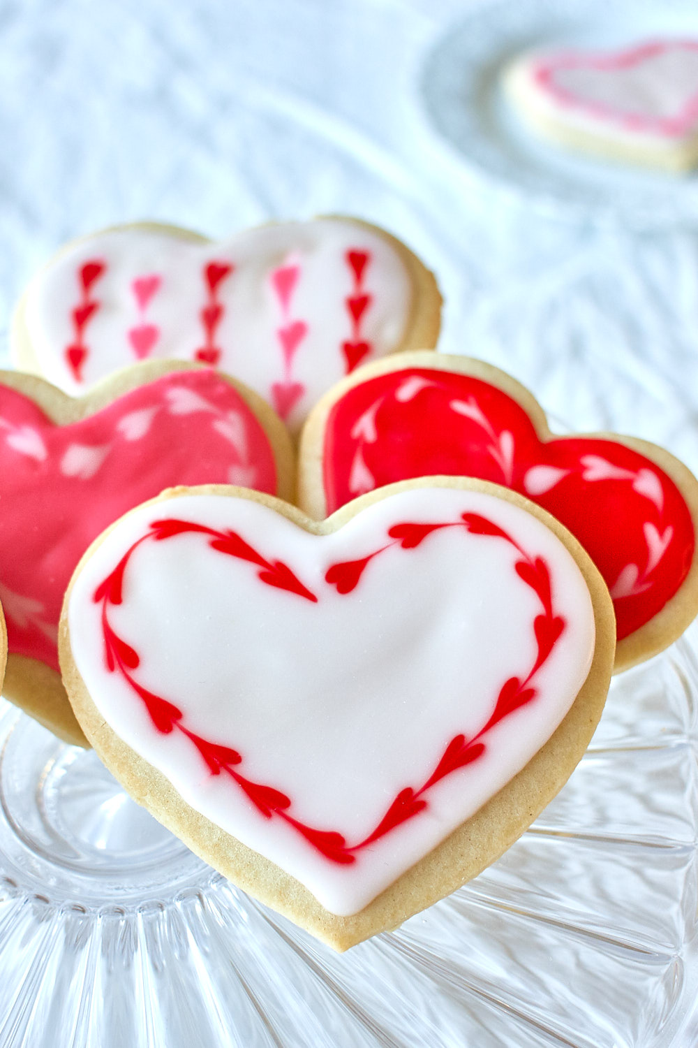 Red and white heart shaped sugar cookies on a plate