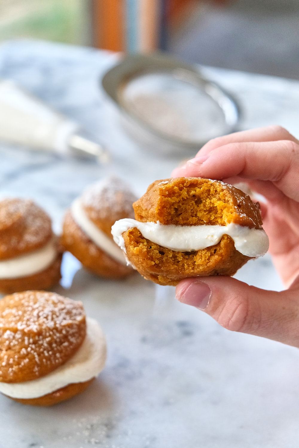Mini pumpkin whoopie pie with a bite taken out of it. 