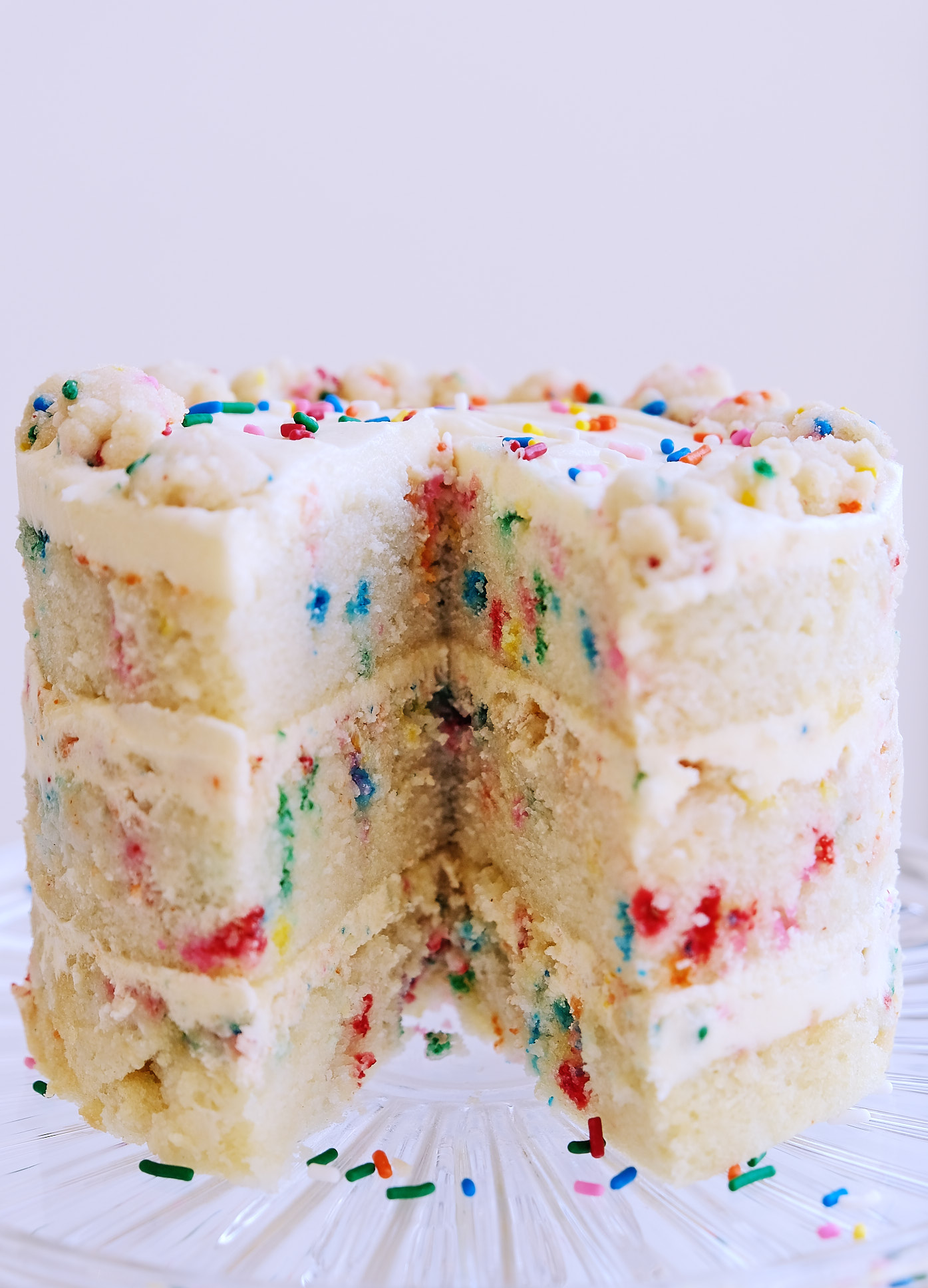 A side view of a dairy-free egg-free Milk Bar Birthday Cake on a cake stand.